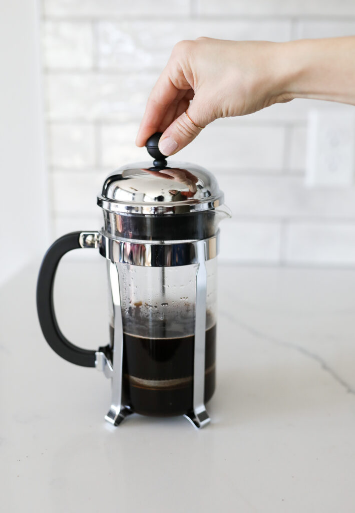 pushing down a french press coffee maker