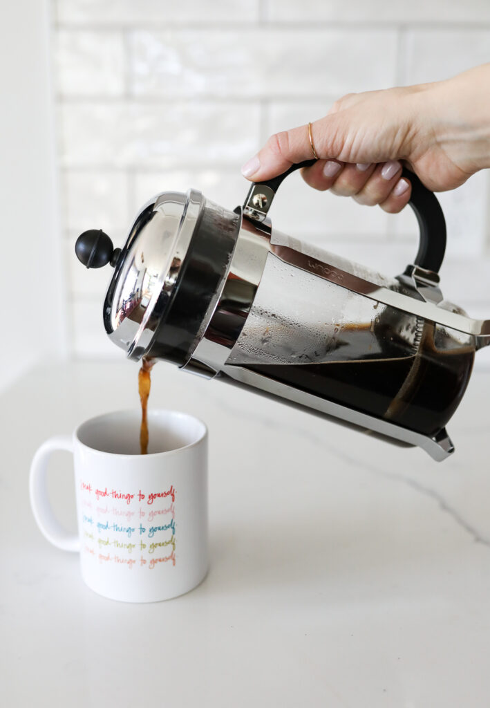 pouring french press coffee into a coffee mug