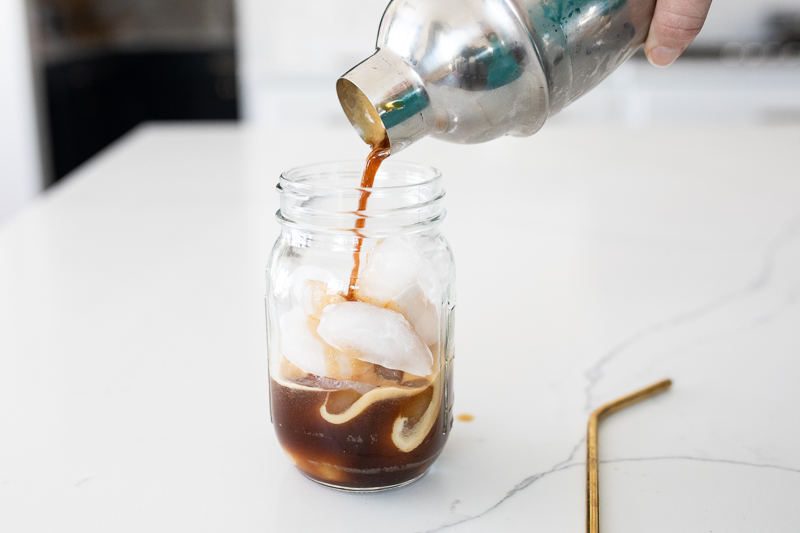 adding espresso to mason jar of ice
