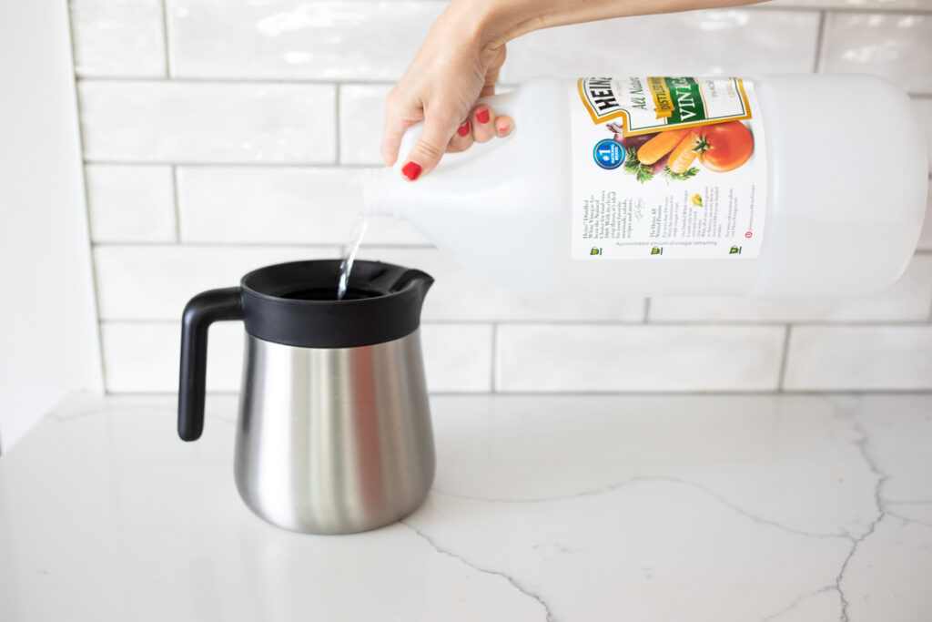 pouring vinegar into a coffee carafe