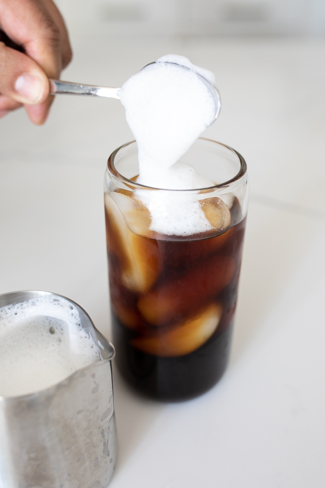 Putting cold foam on an iced coffee