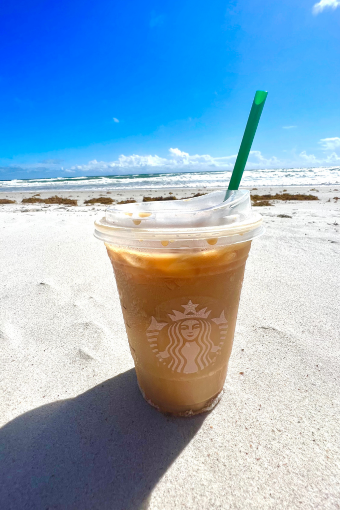 Starbucks Iced Coconut Milk Mocha Macchiato in the sand